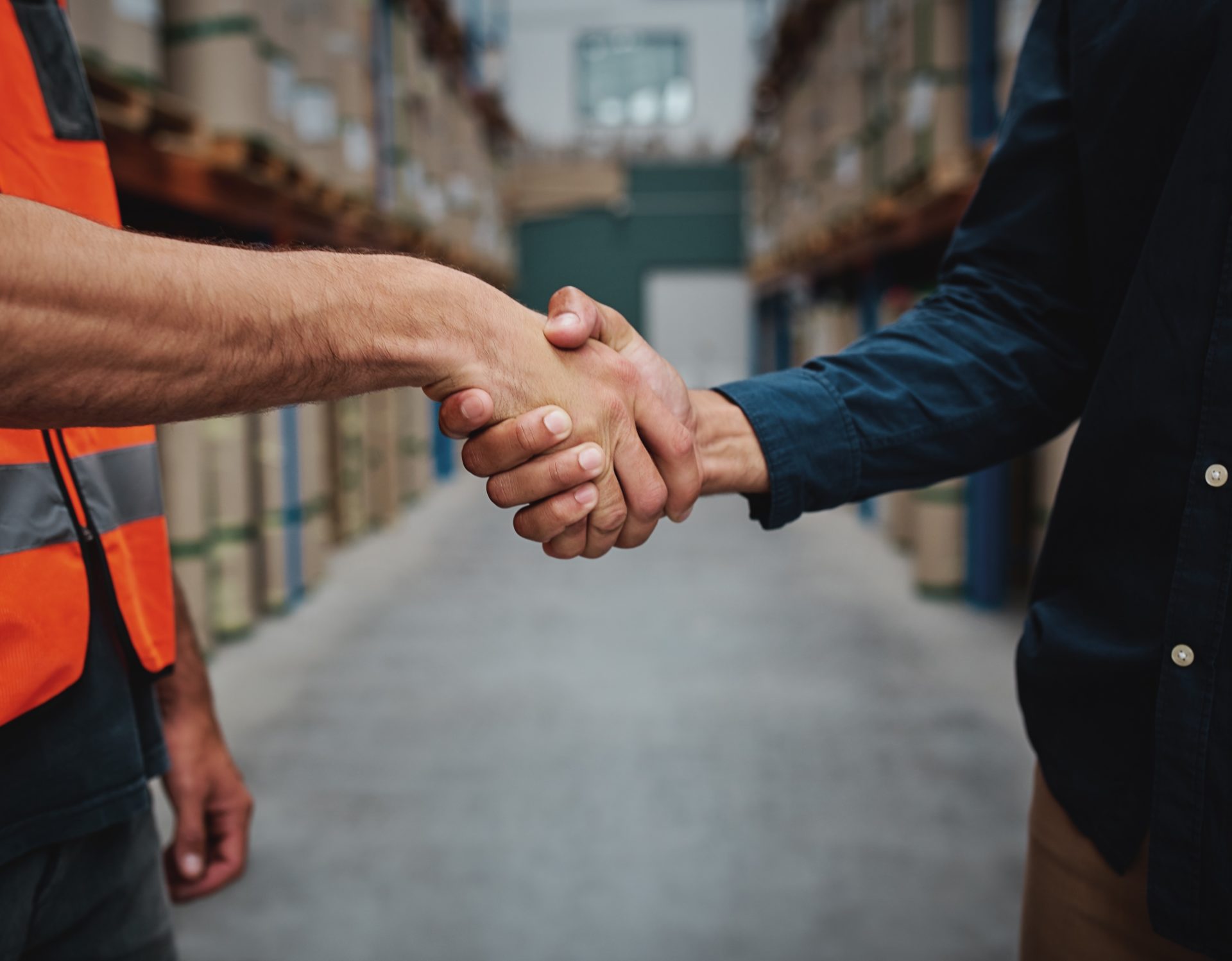 Close-up of two men handshake while concluding agreement about container rent and shaking hands